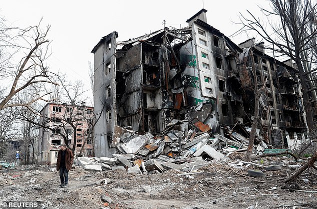 A man walks near a residential building destroyed during Ukraine-Russia conflict in the southern port city of Mariupol, Ukraine April 17, 2026