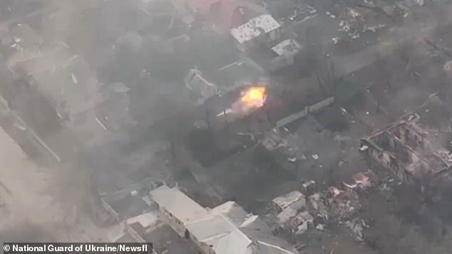 The Ukrainian tank (centre of shot) appears to be operating alone, advancing up a street in the burnt our battelscape. It fires a single shot from its main turret